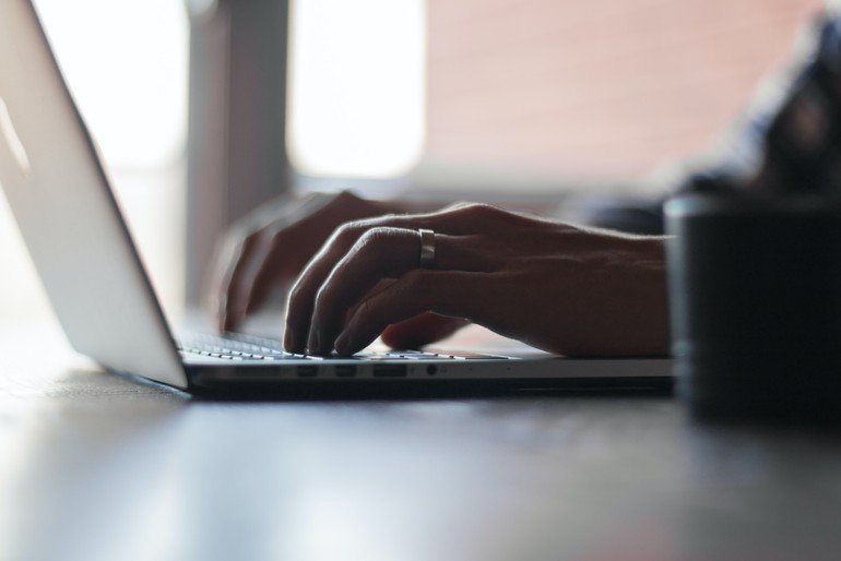 persona escrivint en teclat de portàtil